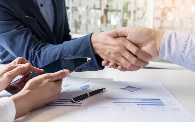 Business handshake of two men demonstrating their agreement to sign agreement or contract between their firms, companies, enterprises